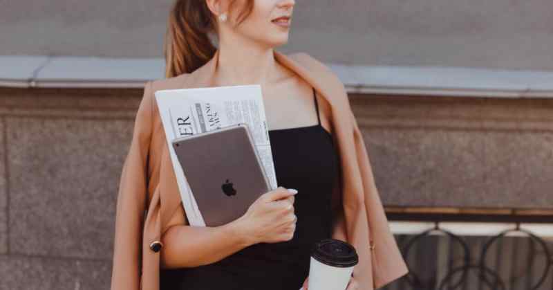 businesswoman holding english newspaper